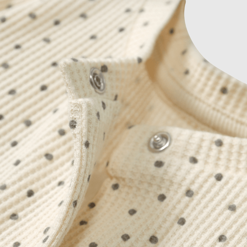 Enterito beige suave para guagua con puntos de diseño tierno